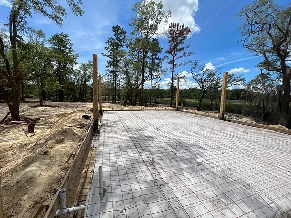 Formed and reinforced building pad on cleared acreage